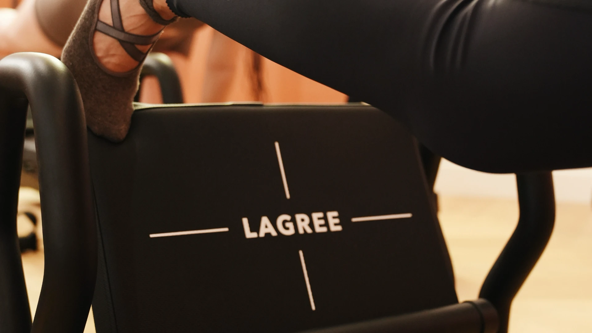 Pied posé sur une machine Lagree fitness, logo LAGREE visible
